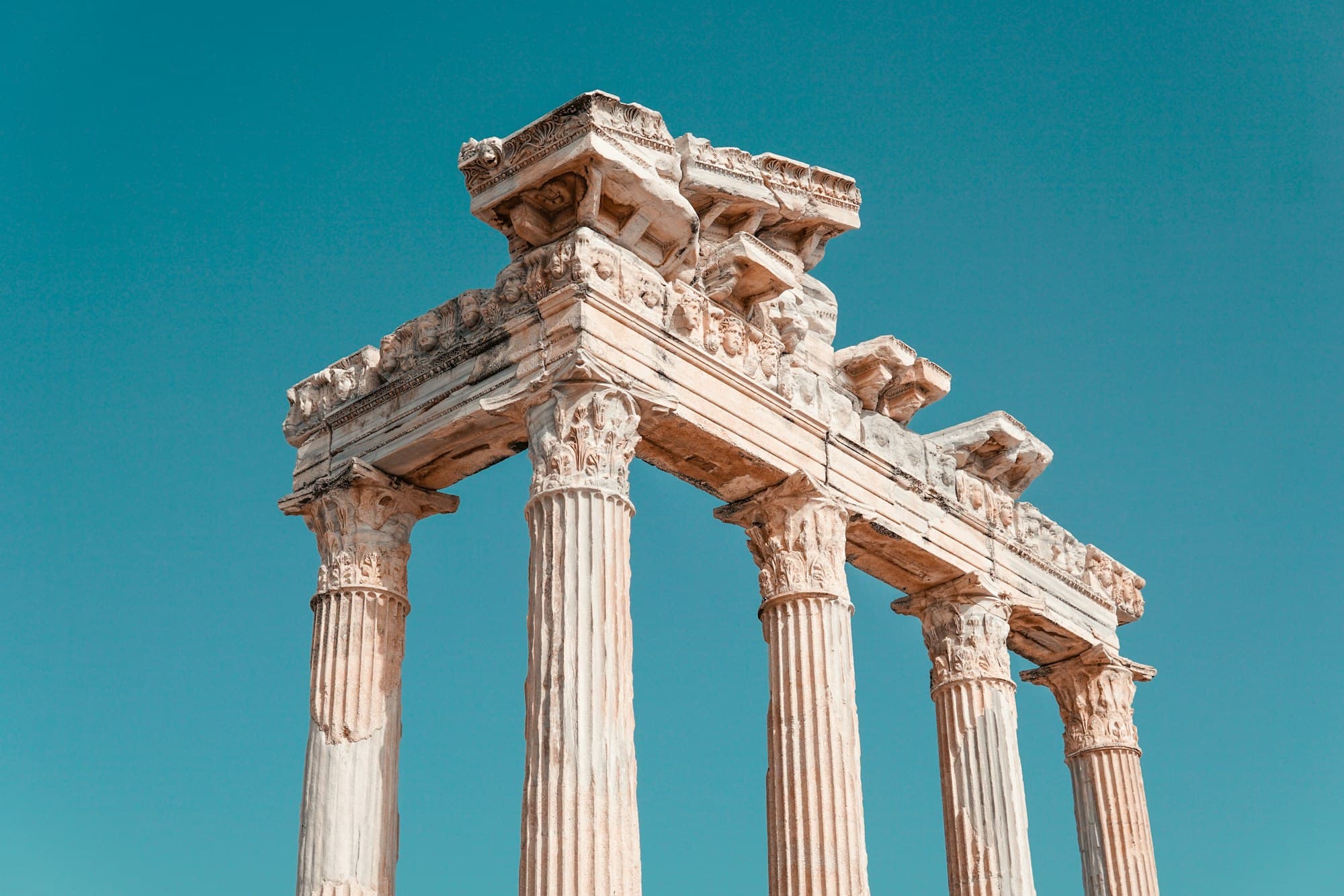 Ancient stone columns and entablature against a clear blue sky